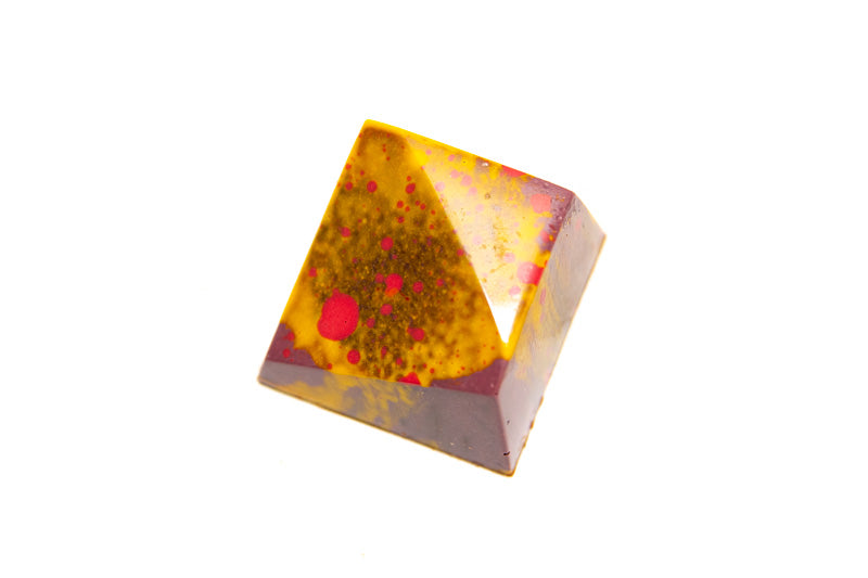 Vierkante praline met een aflopende kant met paarse, gele en rode kleuraccenten